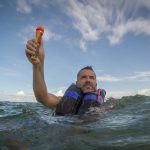 The rescueME EDF1 Electronic flare is being held in the hand of a boater in distress