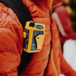 rescueME PLB1 Personal Locator Beacon attached to a hiker's backpack - ensuring safety and security during outdoor adventures