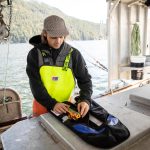 Commercial fishermen mounting an Ocean Signal PLB3 AIS enabled personal locator beacon to an personal floatation device.