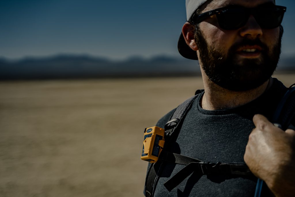 Hiker carrying an Ocean Signal rescueME PLB1 clipped to a backpack shoulder strap